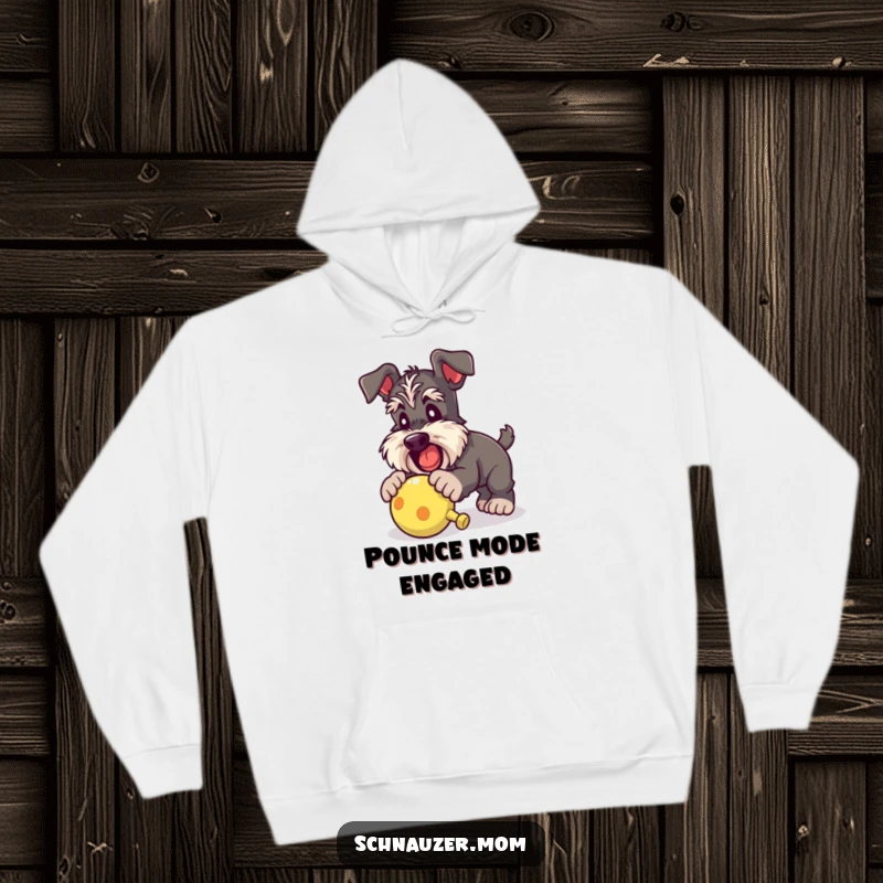 Funny Schnauzer lady hoodie capturing a dog eagerly pouncing on a squeaky toy, embodying playful energy and cozy comfort.