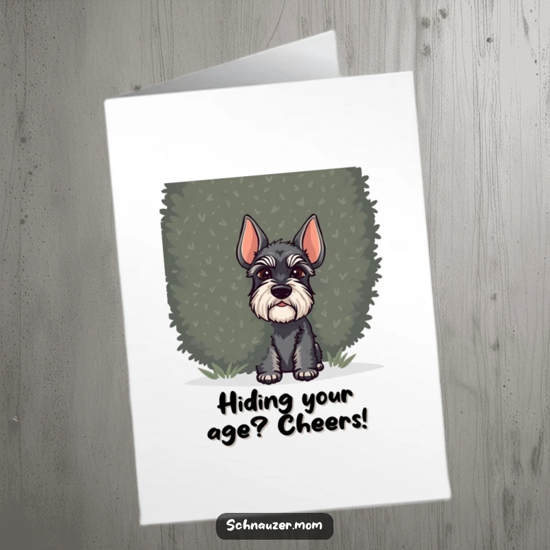Funny Free Printable Birthday Card: Schnauzer dog peeking out playfully from behind a large bushy green shrub.