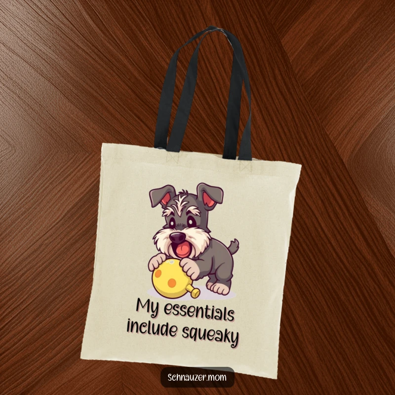 Funny Schnauzer lady tote bag depicting a dog joyfully pouncing on a squeaky toy, ideal for carrying essentials with playful flair.